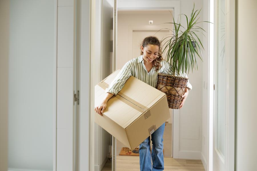 Woman packing belongings to move out after rent increase in a Victorian rental property