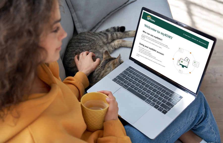 A woman sitting at home on a laptop looking at the myRDRV portal